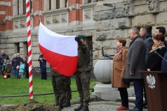 Żołnierze wciągający flagę Polski na maszt.