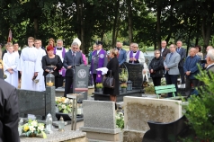Grupa osób na cmentarzu. Mężczyzna przemawia przy mównicy z napisem "Instytut Pamięci Narodowej"