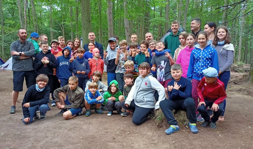 Na zdjęciu grupa osób znajdujących się w lesie